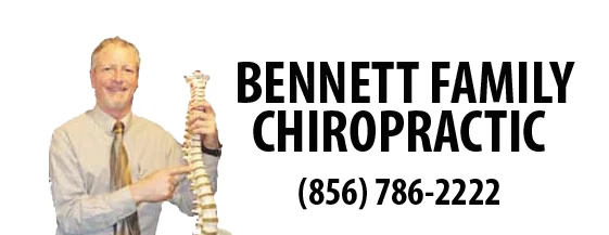 Man in beige shirt and tie holding spine model next to Bennett Family Chiropractic text and phone number